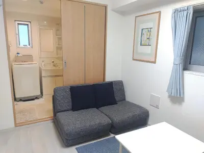 a living room with a couch and a refrigerator at EMILIO Nishi-Shinjuku 101,201,202 - Vacation STAY 64281v in Tokyo