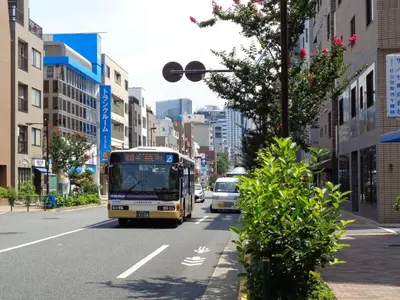 a bus is driving down a city street at EMILIO Nishi-Shinjuku 101,201,202 - Vacation STAY 64281v in Tokyo