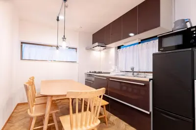 a kitchen with a table and a black refrigerator at HOTEL Y's HOUSE - Vacation STAY 66523v in Tokyo