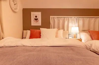 a large bed in a bedroom with a clock on the wall at HOTEL Y's HOUSE - Vacation STAY 66523v in Tokyo