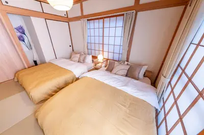 two beds sitting in a room with windows at HOTEL Y's HOUSE - Vacation STAY 66523v in Tokyo