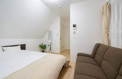 a bedroom with a bed and a couch at Hotel the World Omori in Tokyo