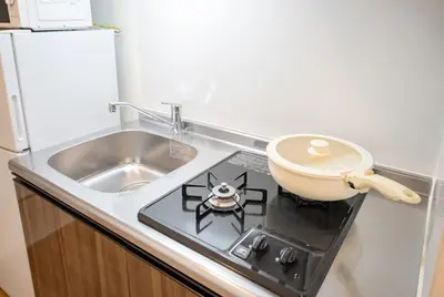 a kitchen with a stove top with a sink at Hotel the World Omori in Tokyo