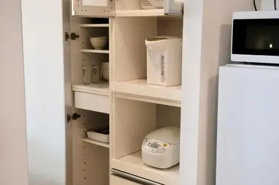 a kitchen pantry with white shelves and a refrigerator at 100㎡ Cozy Villa in Shinjuku｜JR Shin-Ōkubo Sta. 7mins. in Tokyo