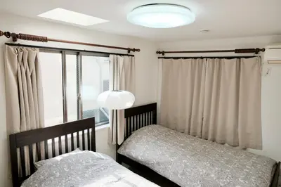 a bedroom with two beds and a window at 100㎡ Cozy Villa in Shinjuku｜JR Shin-Ōkubo Sta. 7mins. in Tokyo