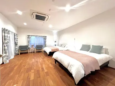 a bedroom with two beds and a room with two chairs at S-asakusa -TT0418 in Tokyo