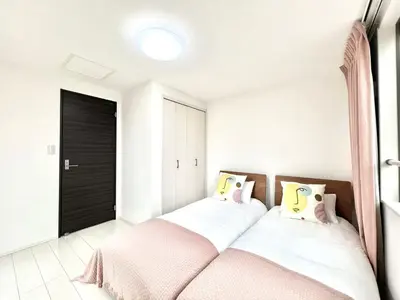 a bedroom with two beds with pink and white at Shinjuku House-SJ0111 in Tokyo