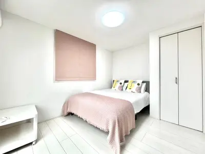 a white bedroom with a bed with a pink blanket at Shinjuku House-SJ0111 in Tokyo