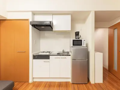 a small kitchen with a refrigerator and a microwave at Dryokan Kabukicho in Tokyo