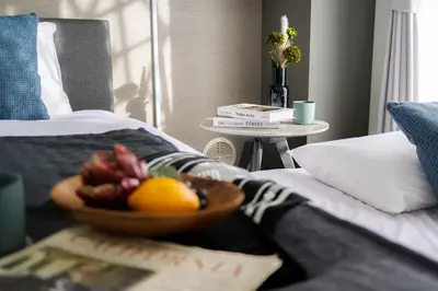 a bowl of fruit on a table next to a bed at Mr Kintaro Higashikomagata in Tokyo