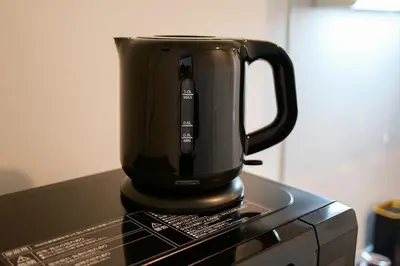a black coffee pot sitting on top of a microwave at Mr Kintaro Higashikomagata in Tokyo
