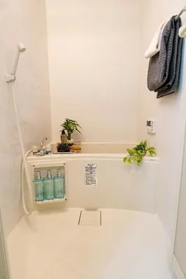 a bathroom with a toilet with two bottles of water at Mr Kintaro Higashikomagata in Tokyo