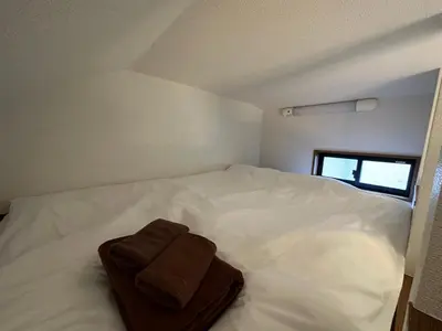 a white bed with a brown towel on it at Max4people Shinjuku 7minutes Shibuya12 minutes LEON RESORT SHIBUYA \u65b0\u5bbf\u6e0b\u8c37 \u6700\u5bc4\u308a\u521d\u53f0\u99c5 \u6700\u59274\u4eba in Tokyo