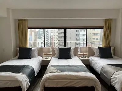 three beds in a room with a large window at Le Tour Hotel Akihabara Kanda \u697d\u9014\u30db\u30c6\u30eb\u795e\u7530\u79cb\u8449\u539f in Tokyo
