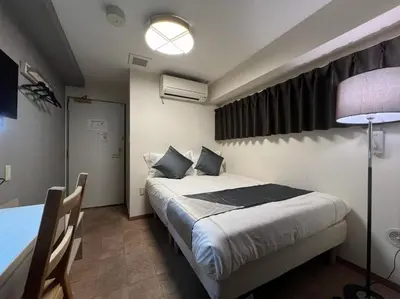 a bedroom with a bed and a lamp and a table at Le Tour Hotel Akihabara Kanda \u697d\u9014\u30db\u30c6\u30eb\u795e\u7530\u79cb\u8449\u539f in Tokyo