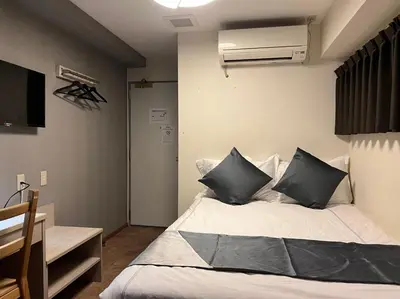 a bedroom with a bed with black pillows at Le Tour Hotel Akihabara Kanda \u697d\u9014\u30db\u30c6\u30eb\u795e\u7530\u79cb\u8449\u539f in Tokyo
