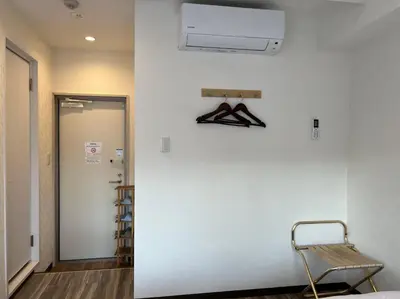 a room with a white wall and a chair next to a door at Le Tour Hotel Akihabara Kanda \u697d\u9014\u30db\u30c6\u30eb\u795e\u7530\u79cb\u8449\u539f in Tokyo