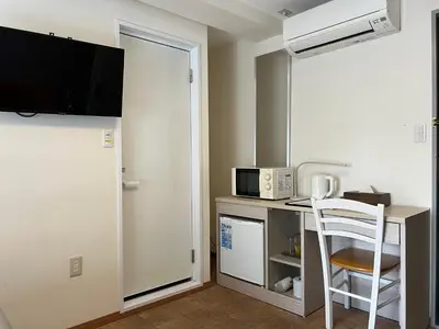 a room with a microwave and a desk with a chair at Le Tour Hotel Akihabara Kanda \u697d\u9014\u30db\u30c6\u30eb\u795e\u7530\u79cb\u8449\u539f in Tokyo