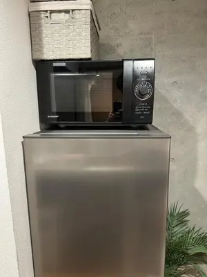 a microwave sitting on top of a refrigerator at Style Lab\u5317\u5343\u4f4f in Tokyo