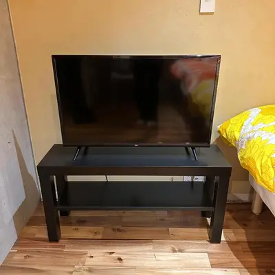 a television on a black table in a room at Style Lab\u5317\u5343\u4f4f in Tokyo