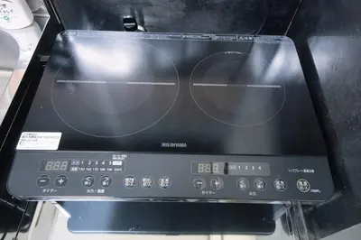 a toaster oven with two glasses on the screen at Reimei House Shinjuku 101 in Tokyo