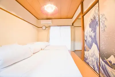 a bedroom with two beds and a chandelier at Reimei House Shinjuku 101 in Tokyo