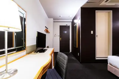 a hotel room with a desk and a bed at Urvest Hotel Kamata in Tokyo