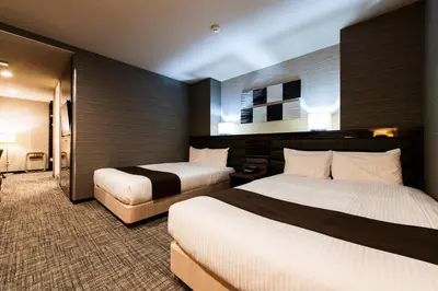 a hotel room with two beds in a room at Urvest Hotel Kamata in Tokyo
