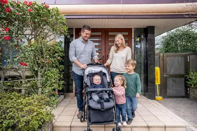 a family with a baby in a stroller outside a house at Family-Friendly 2BR Apt in Tokyo 3 min to Yahiro St ation, Near Skytree in Tokyo