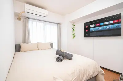 a bedroom with a bed with a tv on the wall at \u65b0\u5bbf\u6b4c\u821e\u4f0e\u753a\u6771\u65b0\u5bbf\u7ad93\u5206\u949f\uff0c\u5f92\u6b65\u4f0a\u52bf\u4e394\u5206\u949f\u514d\u8d39Wi-Fi\uff01 in Tokyo