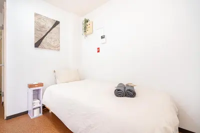 a small bedroom with a bed with a hat on it at \u65b0\u5bbf\u6b4c\u821e\u4f0e\u753a\u6771\u65b0\u5bbf\u7ad93\u5206\u949f\uff0c\u5f92\u6b65\u4f0a\u52bf\u4e394\u5206\u949f\u514d\u8d39Wi-Fi\uff01 in Tokyo