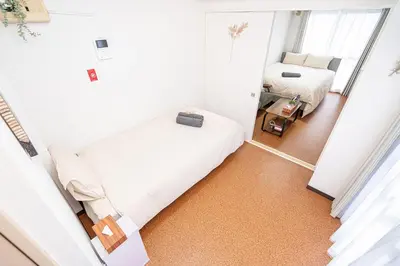 a small room with two beds and a mirror at \u65b0\u5bbf\u6b4c\u821e\u4f0e\u753a\u6771\u65b0\u5bbf\u7ad93\u5206\u949f\uff0c\u5f92\u6b65\u4f0a\u52bf\u4e394\u5206\u949f\u514d\u8d39Wi-Fi\uff01 in Tokyo