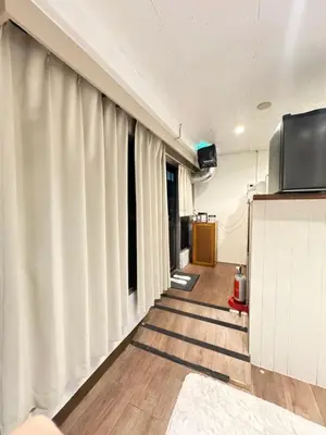a hallway with white curtains and a television at Shinjuku vista point in Tokyo