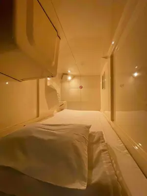 a large white bed in a small room at 男性専用サウナ&カプセル Men Only Capsule Room & Sauna, Bathhouse ミナミ下北沢 Minami Shimokitazawa in Tokyo