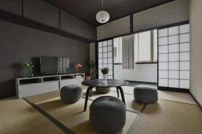 a living room with a table and some stools at \u5ca1\u7530\u30d3\u30eb4\u968e in Tokyo