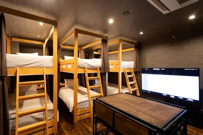 a room with four bunk beds and a flat screen tv at OLD HERITAGE SHIBUYA in Tokyo