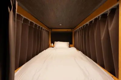 a bed in a room with black curtains at OLD HERITAGE SHIBUYA in Tokyo