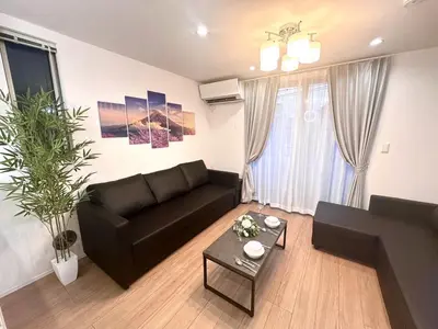 a living room with a black couch and a table at BISK PARK Higashi-Jujo in Tokyo
