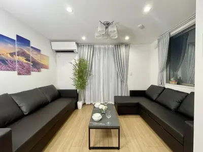 a living room with a black couch and a table at BISK PARK Higashi-Jujo in Tokyo