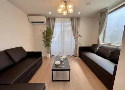 a living room with a black couch and a table at BISK PARK Higashi-Jujo in Tokyo