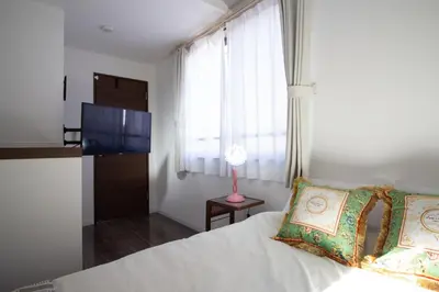 a bedroom with a white bed and a window at QiQi Serenity Tokyo Exclusive New 3-Story Home, 14min to Skytree, Asakusa Area in Tokyo