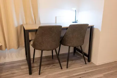 a wooden table with two chairs and a lamp at \u30a8\u30ea\u30af\u30b5\u30fc\u30e1\u30be\u30f3\u4ee3\u7530\u6a4b in Tokyo