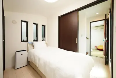 a bedroom with a white bed and a sliding glass door at Ikebukuro house with 3BR Shinjuku 5min in Tokyo