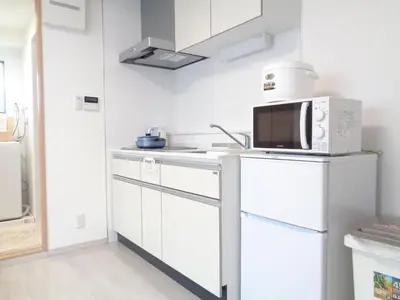 a kitchen with white cabinets and a microwave at EMILIO158 - Quiet residential area near Shinjuku Free Wi-Fi in Tokyo