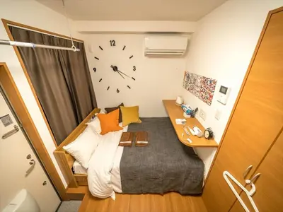 a small bedroom with a bed and a clock on the wall at Maison de Takinogawa - Vacation STAY 16164 in Tokyo