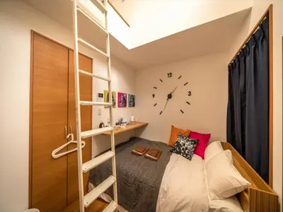 a bedroom with a bunk bed and a clock on the wall at Maison de Takinogawa - Vacation STAY 16163 in Tokyo