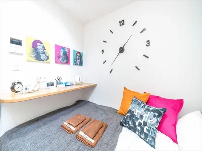 a bedroom with a bed with a clock on the wall at Maison de Takinogawa - Vacation STAY 16163 in Tokyo