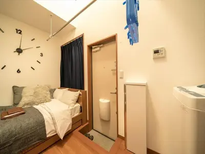 a bedroom with a bed and a clock on the wall at Maison de Takinogawa - Vacation STAY 16165 in Tokyo