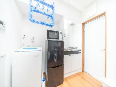 a kitchen with a refrigerator and a microwave at Maison de Takinogawa - Vacation STAY 16165 in Tokyo