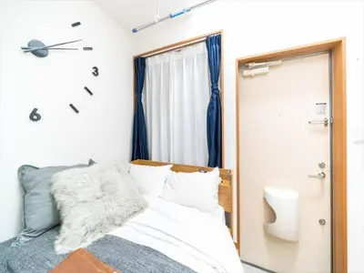 a bedroom with a bed and a clock on the wall at Maison de Takinogawa - Vacation STAY 16165 in Tokyo